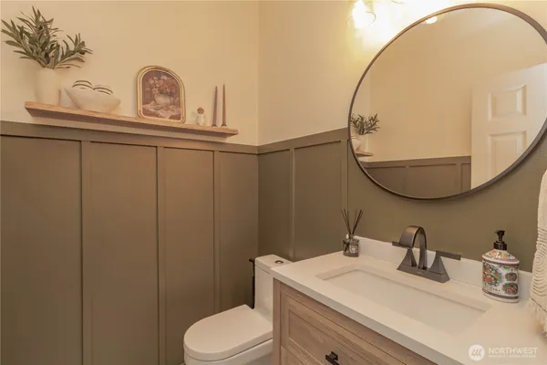 a bathroom with a sink vanity mirror and toilet