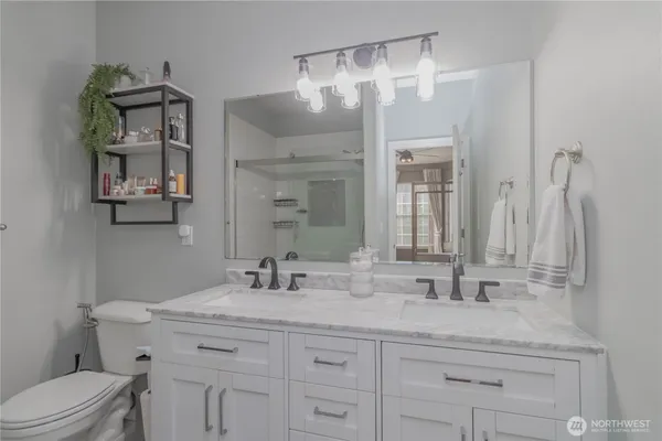 a bathroom with a granite countertop sink a toilet and a mirror
