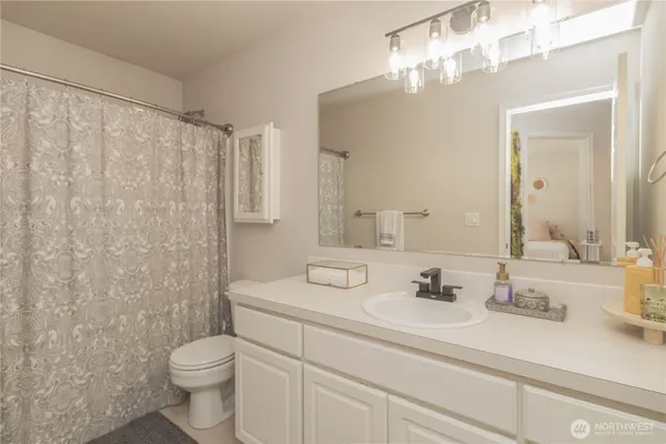 a bathroom with a sink a toilet and a mirror