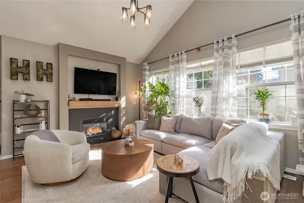 a living room with furniture a flat screen tv and a large window
