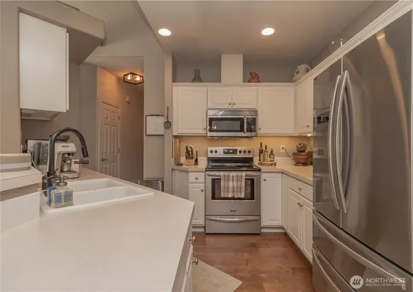 a kitchen with kitchen island a sink stainless steel appliances and cabinets