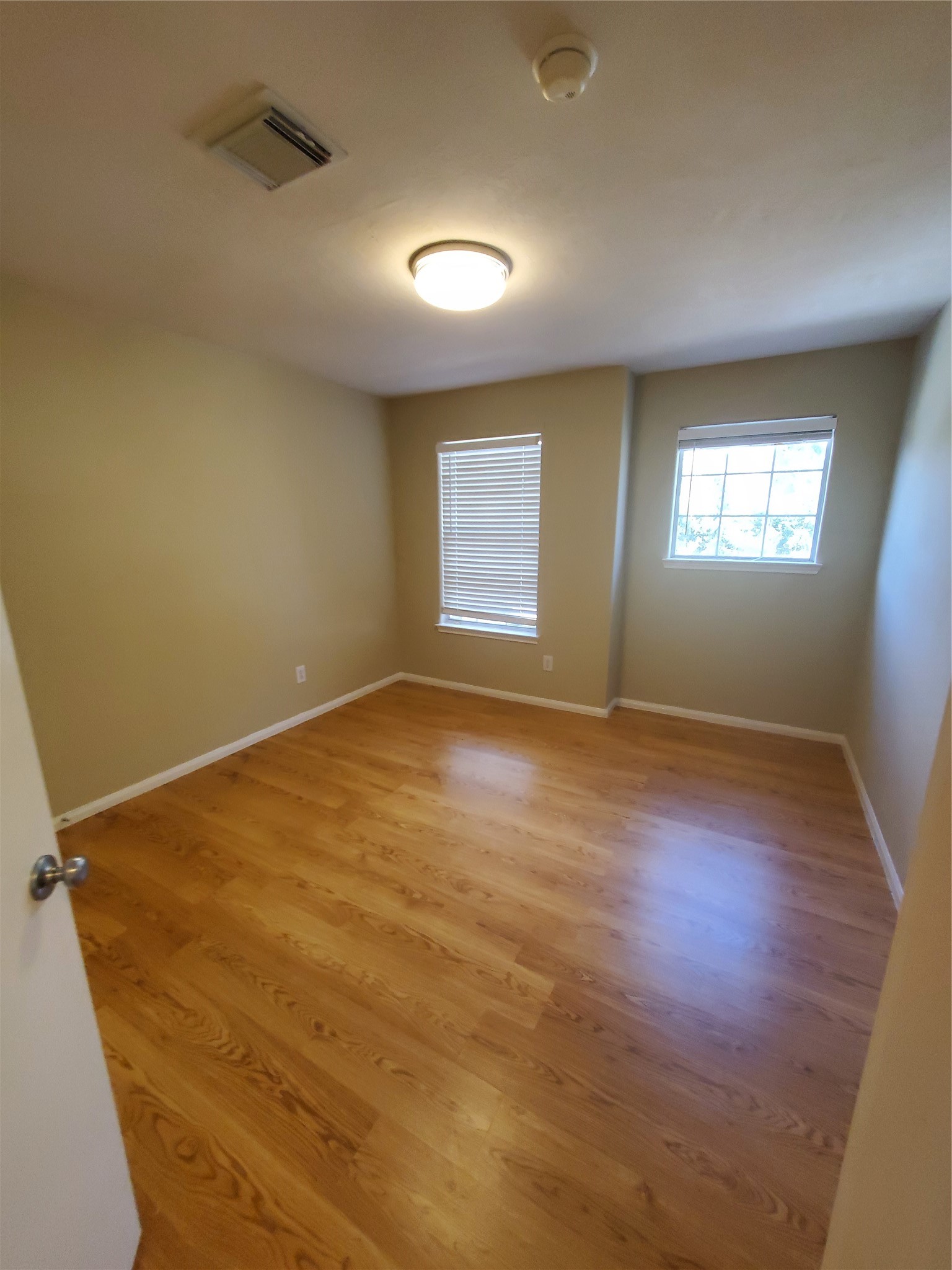9342 Canady Park Lane Houston, TX 77075 - Photo 21 of 25 an empty room with wooden floor and windows