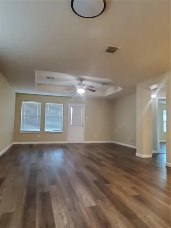 a view of an empty room with wooden floor