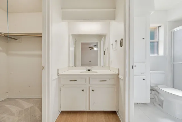 a bathroom with a granite countertop sink mirror and a toilet