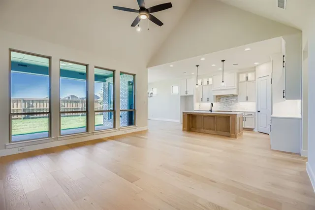 a view of a kitchen with kitchen island a sink and a large window