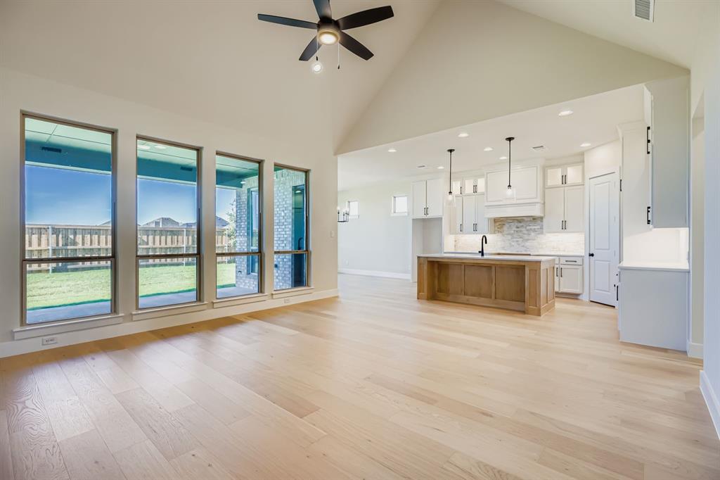 4813 Strada Street Prosper, TX 75078 - Photo 5 of 28 a view of a kitchen with kitchen island a sink and a large window