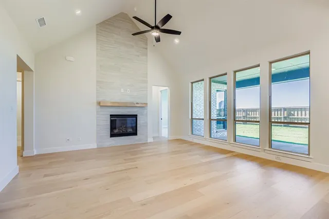 a view of an empty room with a fireplace and a window