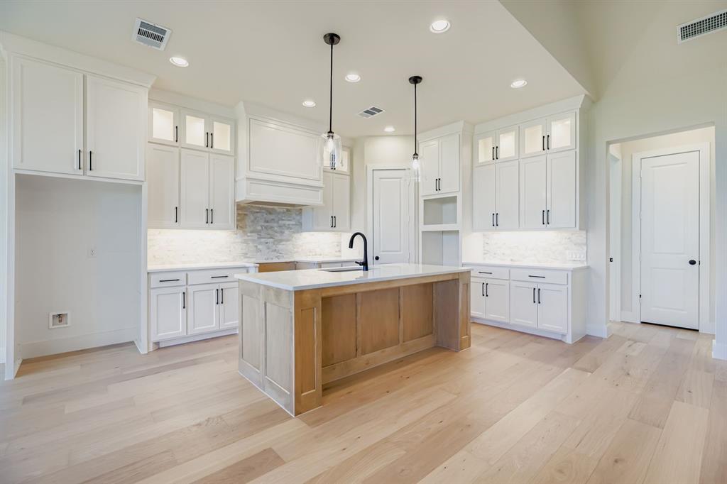 4813 Strada Street Prosper, TX 75078 - Photo 7 of 28 a large white kitchen with a lot of counter space