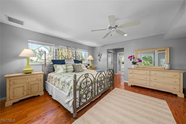 a bedroom with a bed dresser and wooden floor