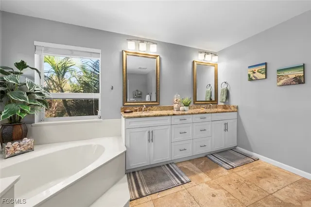 a spacious bathroom with a tub sink and mirror