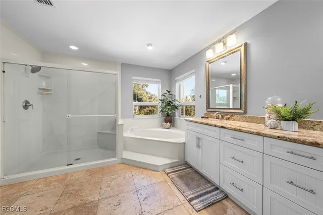a spacious bathroom with a shower sink and mirror