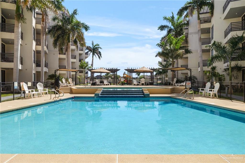 813 Travis Street, Unit 314 Mission, TX 78572 - Photo 18 of 26 a view of a swimming pool with a table and chairs