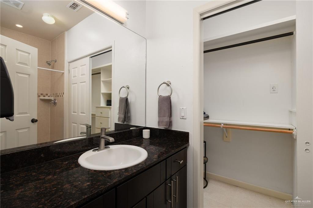 813 Travis Street, Unit 314 Mission, TX 78572 - Photo 9 of 26 a bathroom with a granite countertop sink and a mirror
