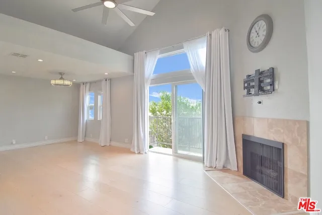 a view of kitchen with kitchen island a sink wooden floor and a refrigerator