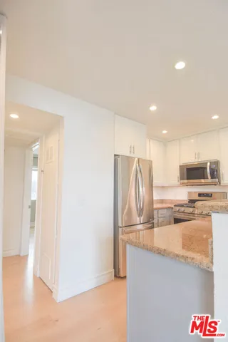 a kitchen with stainless steel appliances granite countertop a sink and a refrigerator