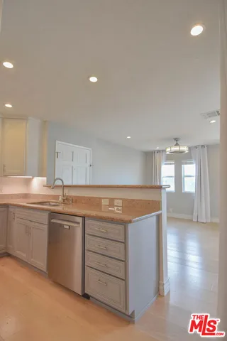 a kitchen with a refrigerator and a stove top oven