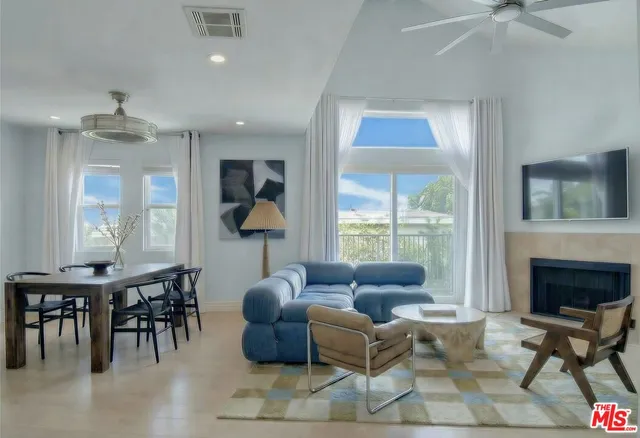 a living room with furniture a fireplace and a large window