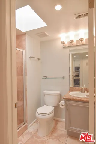 a bathroom with a granite countertop sink a toilet and a mirror