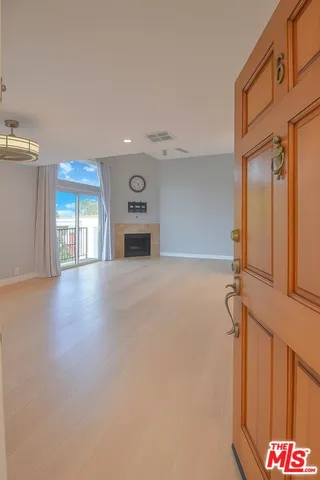 a view of an empty room with a fireplace and a window