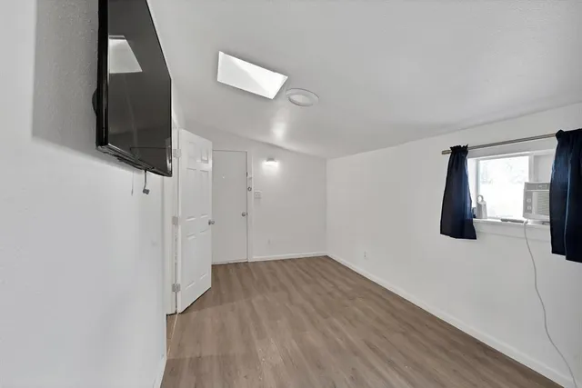 a view of a livingroom with wooden floor and a flat screen tv