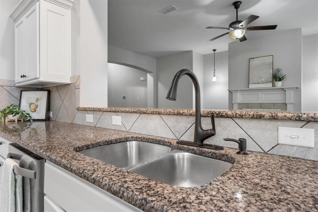 151 Birdsong Lane Terrell, TX 75160 - Photo 13 of 28 Close-up of the kitchen sink area featuring granite countertops, modern fixtures, and a stylish tile backsplash.