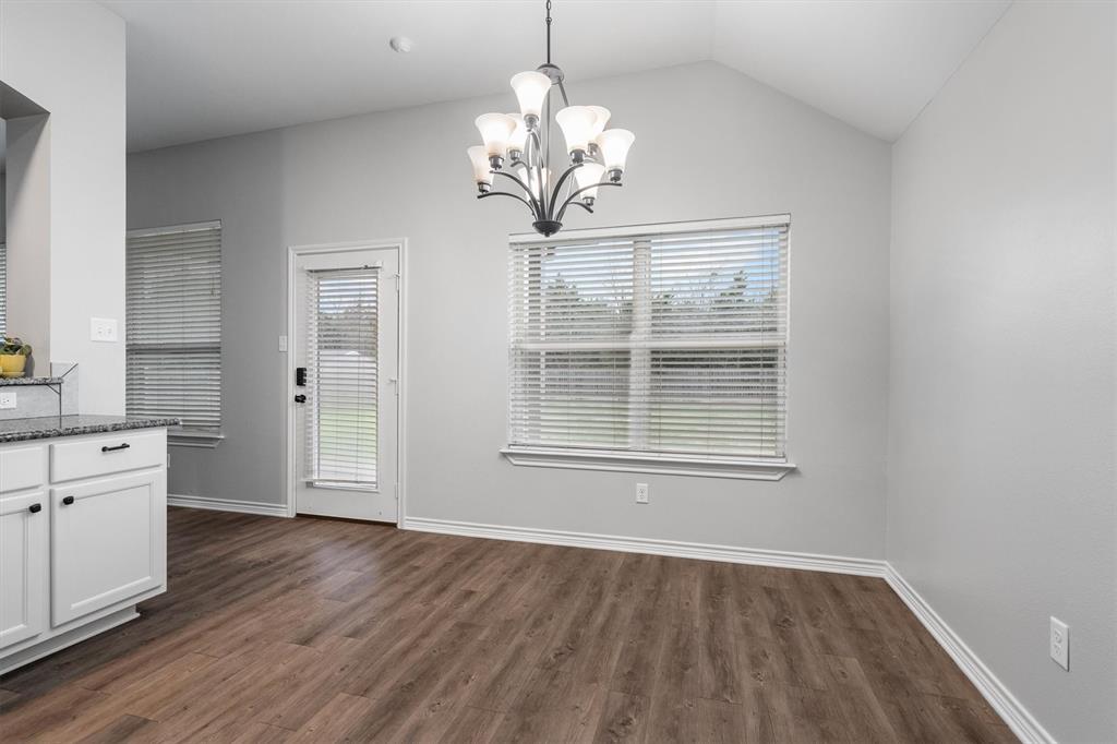 151 Birdsong Lane Terrell, TX 75160 - Photo 16 of 28 Dining area with wood-style flooring, elegant chandelier, and large windows that bring in natural light.