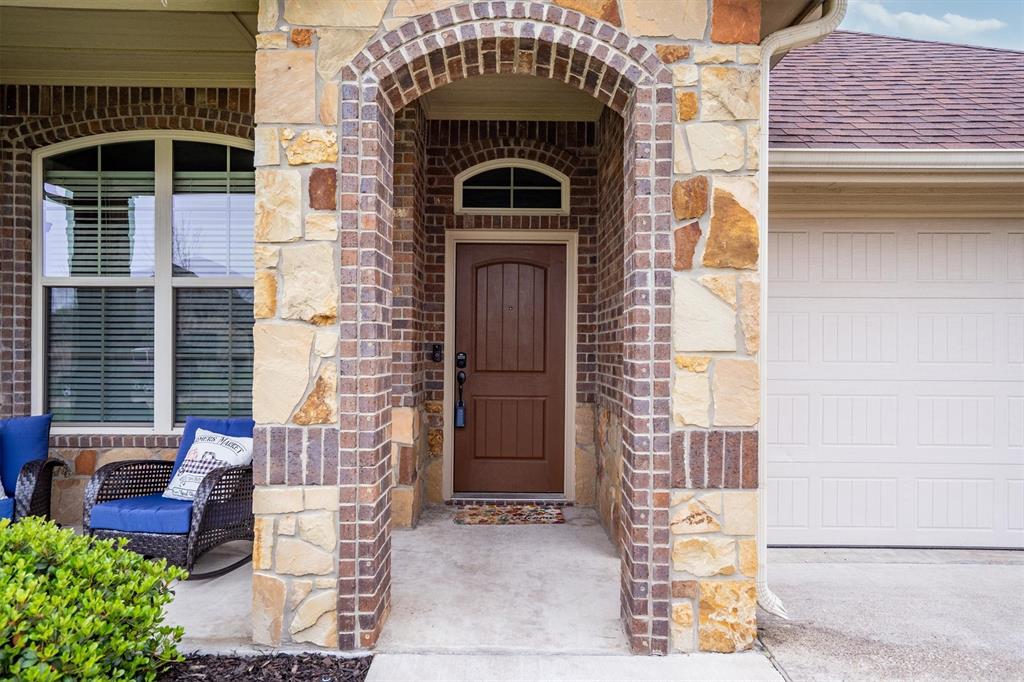 151 Birdsong Lane Terrell, TX 75160 - Photo 5 of 28 Close-up view of the front entry highlighting the decorative stone façade and sheltered porch area.