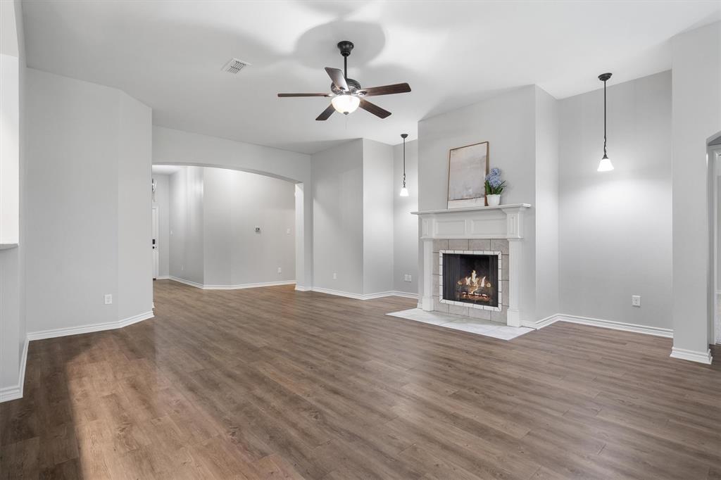 151 Birdsong Lane Terrell, TX 75160 - Photo 7 of 28 Spacious living room featuring wood-style flooring, abundant natural light, and a cozy fireplace as the focal point.