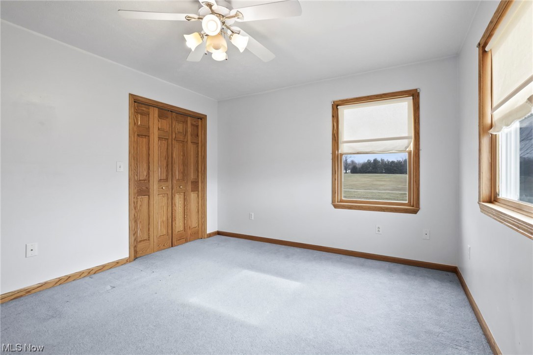 411 Adario West Road Shiloh, OH 44878 - Photo 22 of 35 Unfurnished bedroom featuring a closet, ceiling fan, and light colored carpet