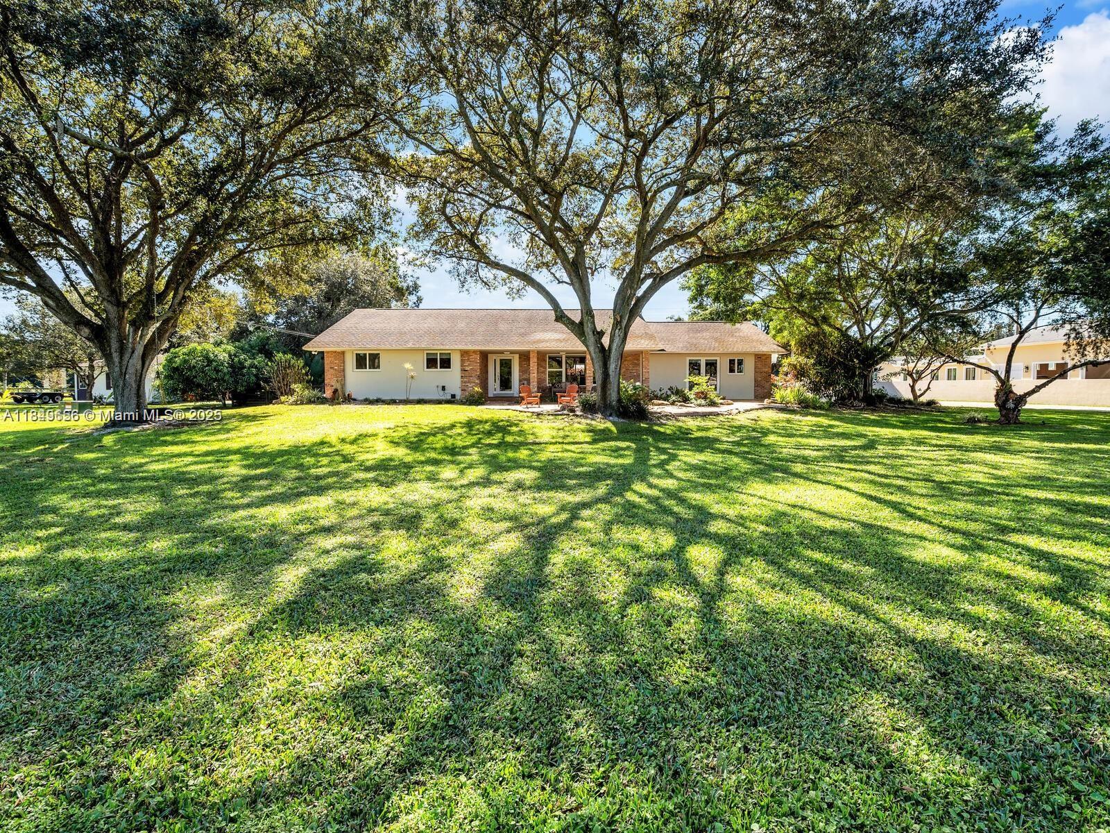 13350 Luray Road Southwest Ranches, FL 33330 - Photo 1 of 56 a front view of a house with a garden