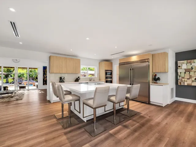 a kitchen with a white cabinets and chairs