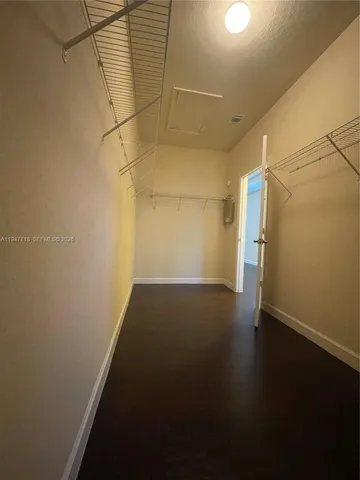 an empty room with a ceiling fan and closet area