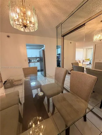 a living room with furniture a chandelier and a dining table