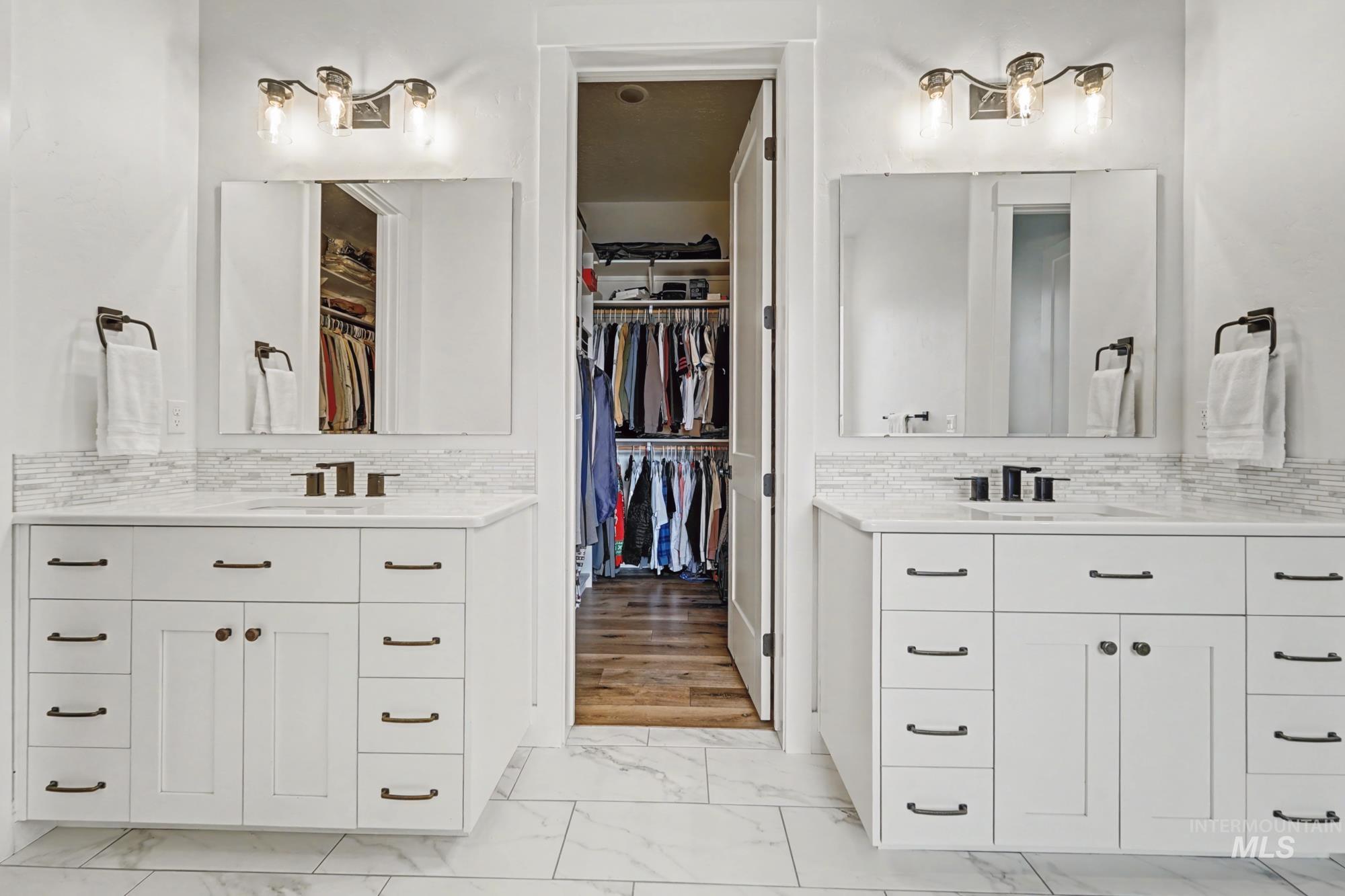 18357 North Burnt Car Way Boise, ID 83714 - Photo 27 of 48 Bathroom featuring two vanities, a walk in closet, and tasteful backsplash