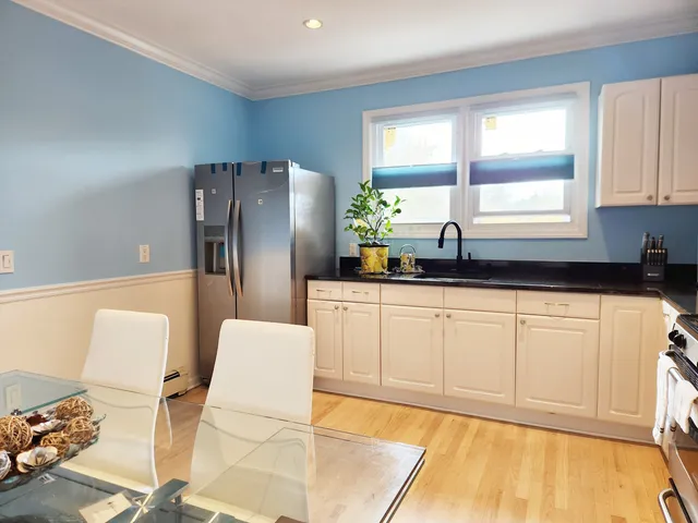 a kitchen with granite countertop white cabinets and white appliances