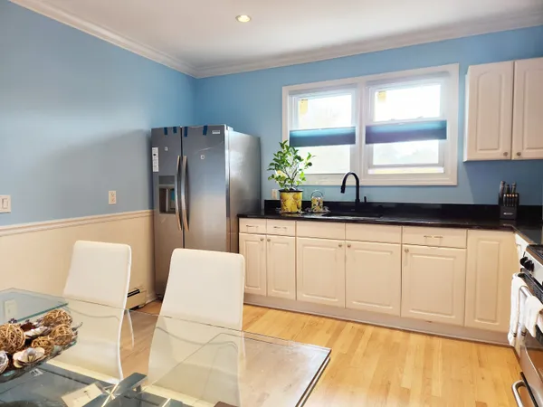 a kitchen with stainless steel appliances a refrigerator sink and white cabinets