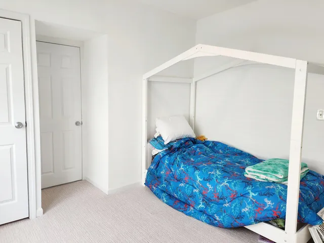 a bedroom with a bed and a painting on the wall