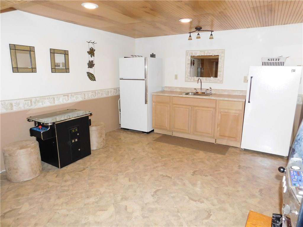 105 Spohn Road Freeport, PA 16229 - Photo 20 of 25 Lower level party kitchen with wainscoting ceiling, Karndean tile flooring...even your own telephone booth!!! Huge storage room off of this room along with access to heated 2 car integral garage.