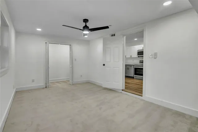 an empty room with closet and windows