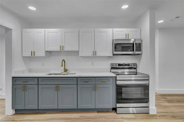 a kitchen with appliances a sink and cabinets