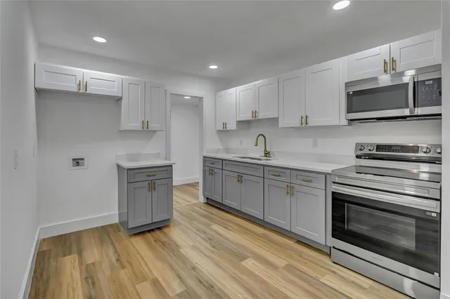 a kitchen with stainless steel appliances granite countertop a sink and a stove top oven