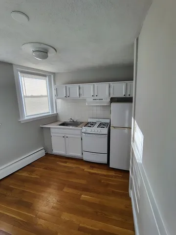 a kitchen with a refrigerator sink and cabinets