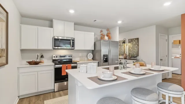 a open dining room with stainless steel appliances kitchen island granite countertop a stove a sink a dining table and chairs