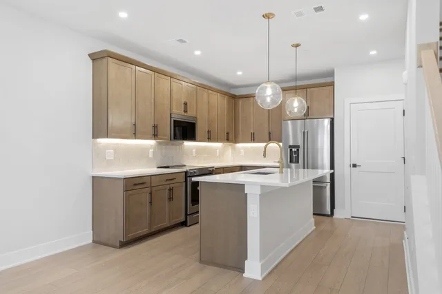 a large kitchen with stainless steel appliances granite countertop a sink a stove and a refrigerator