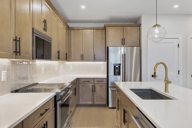 a kitchen with granite countertop a sink stove and refrigerator