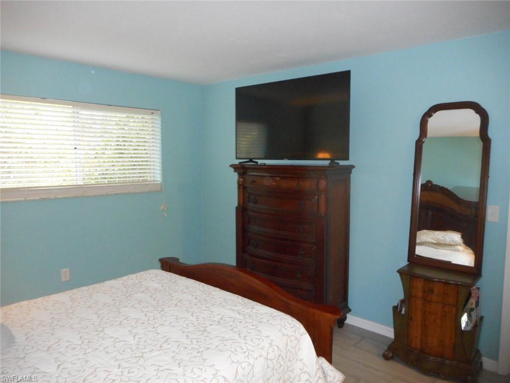 1007 Pine Isle Lane, Unit 1007 Naples, FL 34112 - Photo 13 of 22 a bedroom with a bed and a television