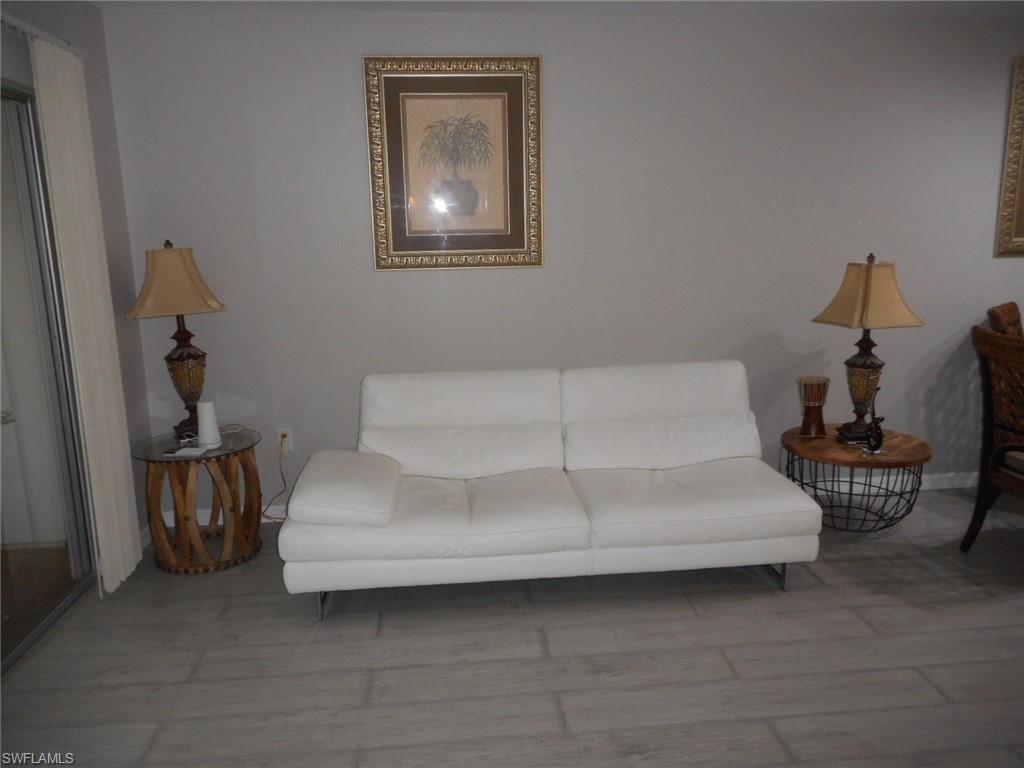 1007 Pine Isle Lane, Unit 1007 Naples, FL 34112 - Photo 15 of 22 a living room with furniture and a lamp