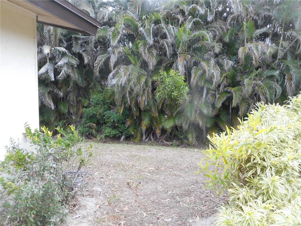 1007 Pine Isle Lane, Unit 1007 Naples, FL 34112 - Photo 4 of 22 a view of a yard with plants and wooden fence