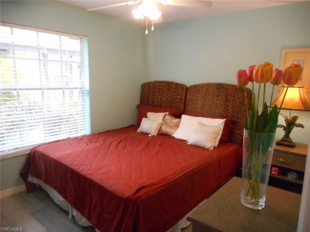 1007 Pine Isle Lane, Unit 1007 Naples, FL 34112 - Photo 7 of 22 a bed sitting in a bedroom next to a window