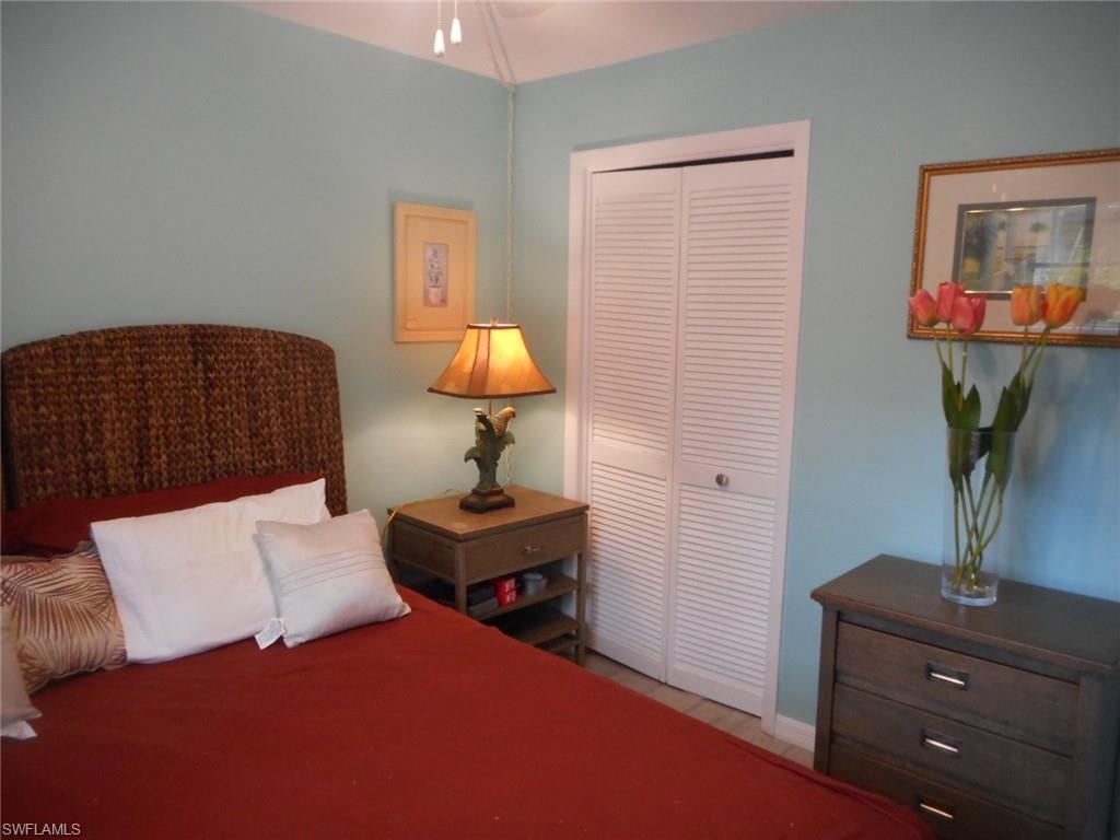 1007 Pine Isle Lane, Unit 1007 Naples, FL 34112 - Photo 8 of 22 a bedroom with a bed and a potted plant